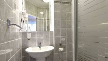 A modern bathroom with a sink, toilet, and shower area.