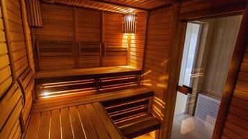 A wooden sauna with benches and a sloped ceiling.