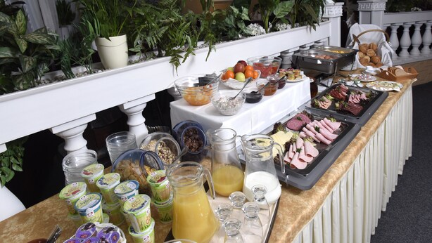 A buffet table with various food items and beverages. - LAT Hotel & Apartmenthaus Berlin (Eisenhuettenstadt)