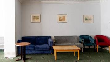 A living room with a blue sofa, a grey sofa, a wooden coffee table, and two chairs.