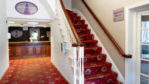 A staircase with a red carpet leading to a sign indicating the direction to the bedrooms. - Norwich Central Hotel - Near Norwich Train Station & Carrow Road Stadium (Norwich)
