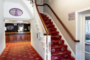 A staircase with a red carpet leading to a sign indicating the direction to the bedrooms. - Norwich Central Hotel - Near Norwich Train Station & Carrow Road Stadium (Norwich)