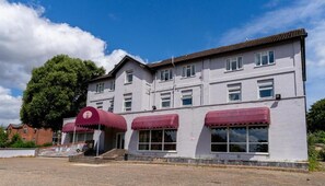 A two-story building with a flat roof, multiple windows, and a red awning over the entrance. - Norwich Central Hotel - Near Norwich Train Station & Carrow Road Stadium (Norwich)