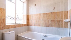 A bathroom with a bathtub, toilet, and sink. - Norwich Central Hotel - Near Norwich Train Station & Carrow Road Stadium (Norwich)