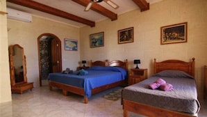 A bedroom with two wooden beds, a ceiling fan, and a mirror. - Happy & Healthy Farmhouse Gozo (Gharb)