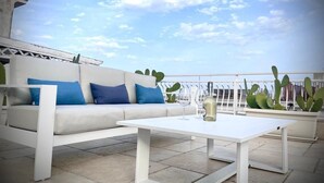 A rooftop terrace with a white sofa, a white coffee table, and potted cacti. - Casa Manfredi B&B (Manfredonia)