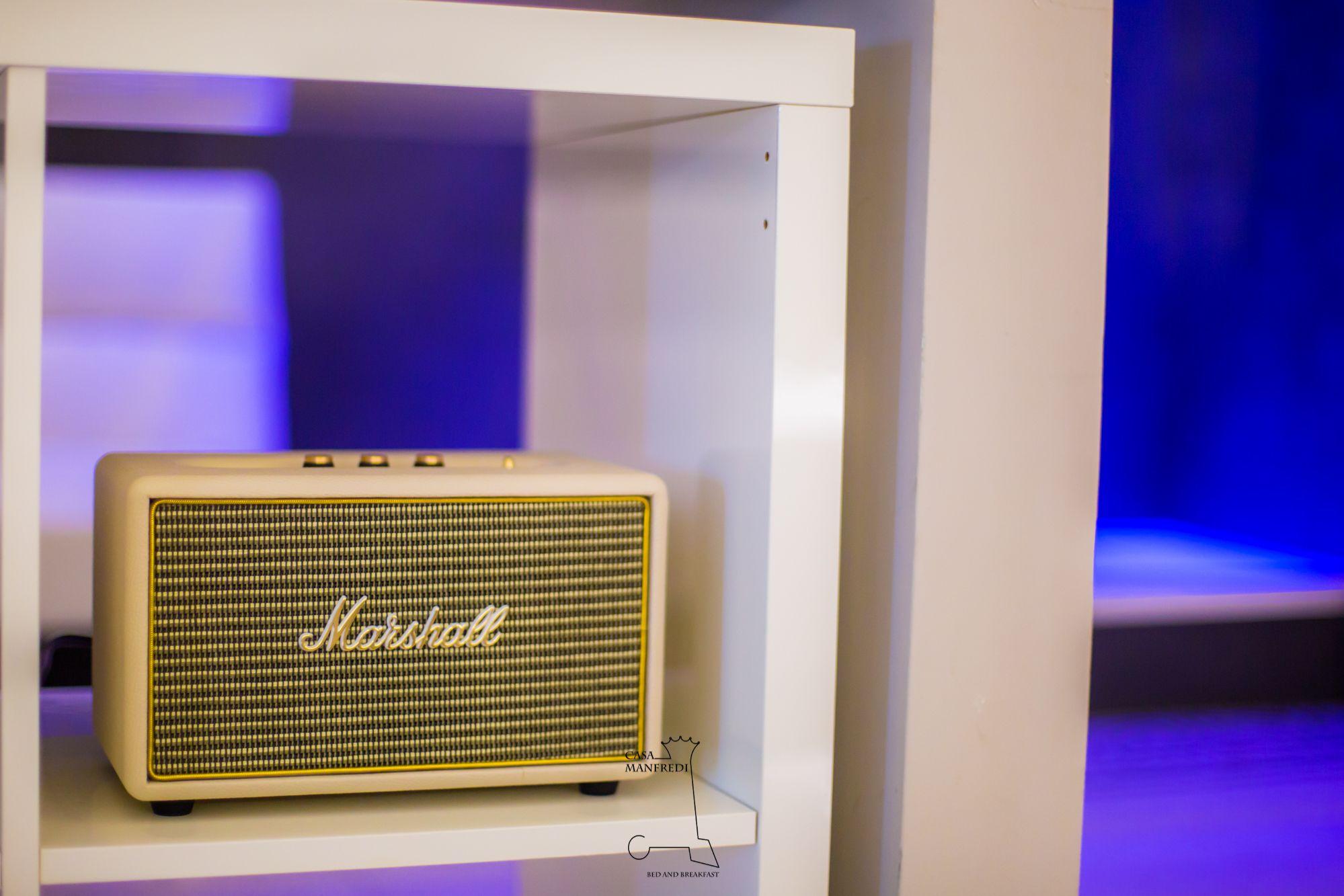 A vintage Marshall speaker in a white display case.