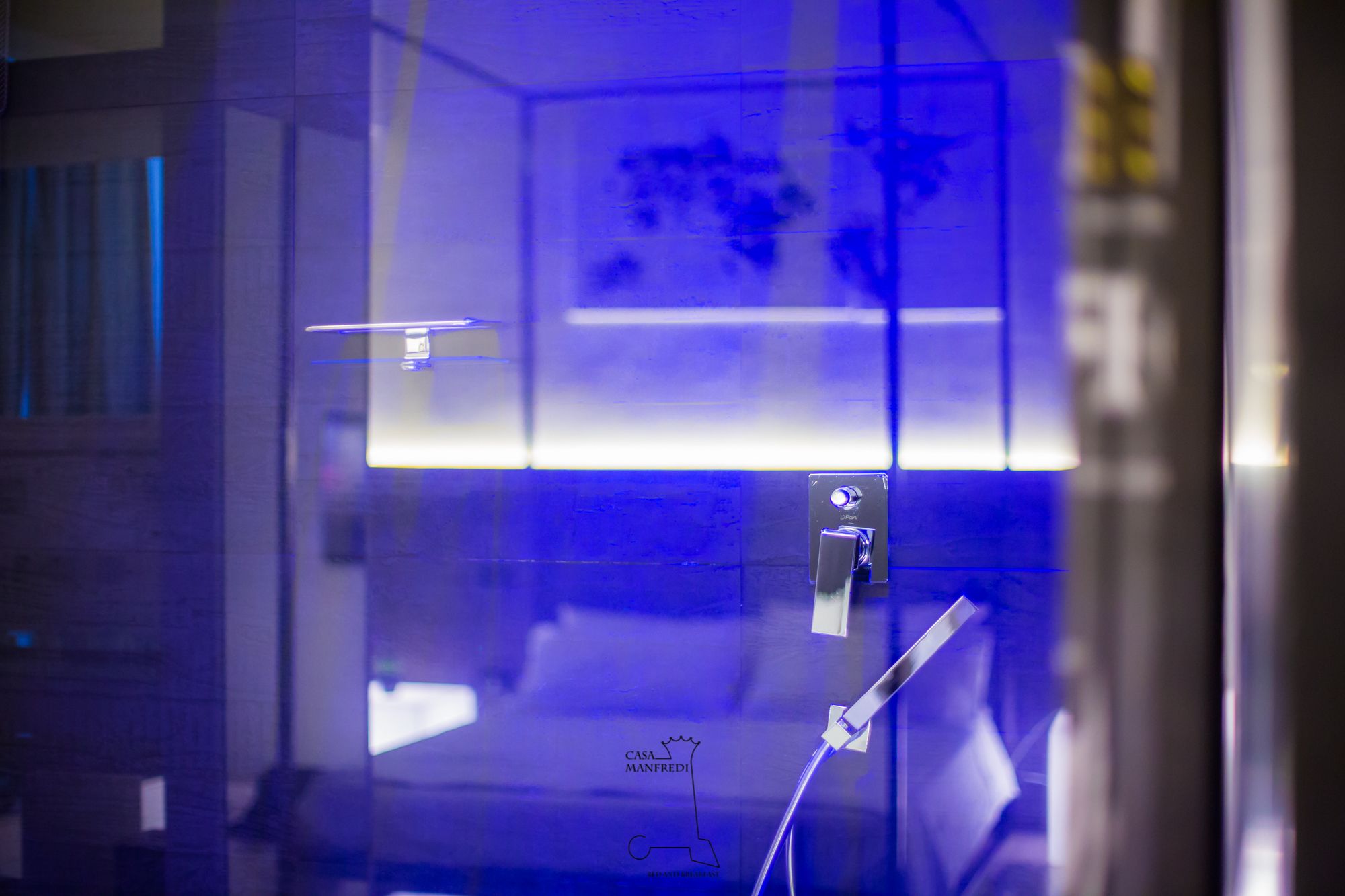 A modern bathroom with a glass shower enclosure, a visible towel rack, and a visible sink area.