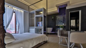 A modern hotel room with a bed, a desk, a chair, and a bathroom area. - Casa Manfredi B&B (Manfredonia)