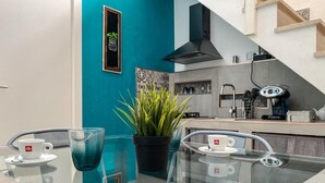 Een moderne keuken met een zwarte afzuigkap, een spoelbak en een aanrecht met een koffieapparaat.
