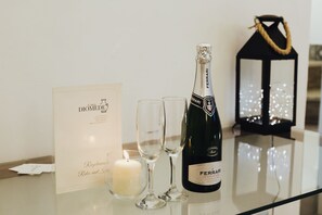 A bottle of Ferrari wine, two glasses, a lit candle, and a sign on a table. - Casa Diomede B&B (Manfredonia)