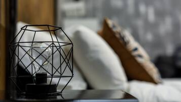 Een moderne lamp met een geometrisch ontwerp op een nachtkastje in een slaapkamer.