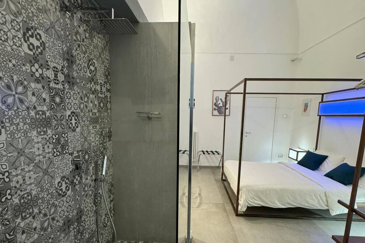 Une salle de bain moderne avec des carreaux décorés, une douche et un lit à baldaquin.
