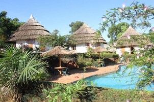 Una piscina al aire libre, sillones reclinables de piscina