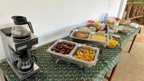 A buffet setup with various food items, a coffee machine, and a water dispenser.