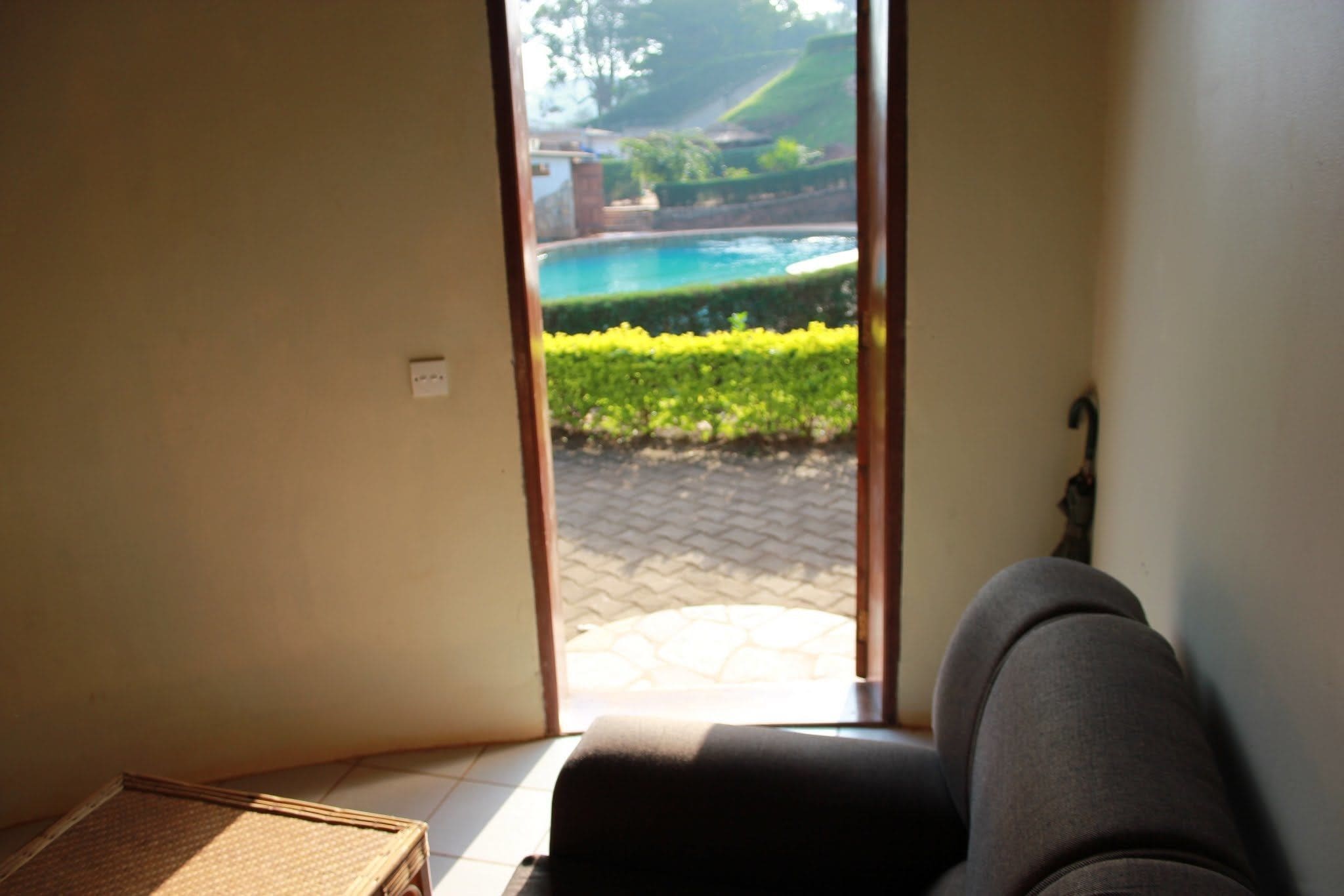Habitación con vista a una piscina y jardín a través de un ventanal.