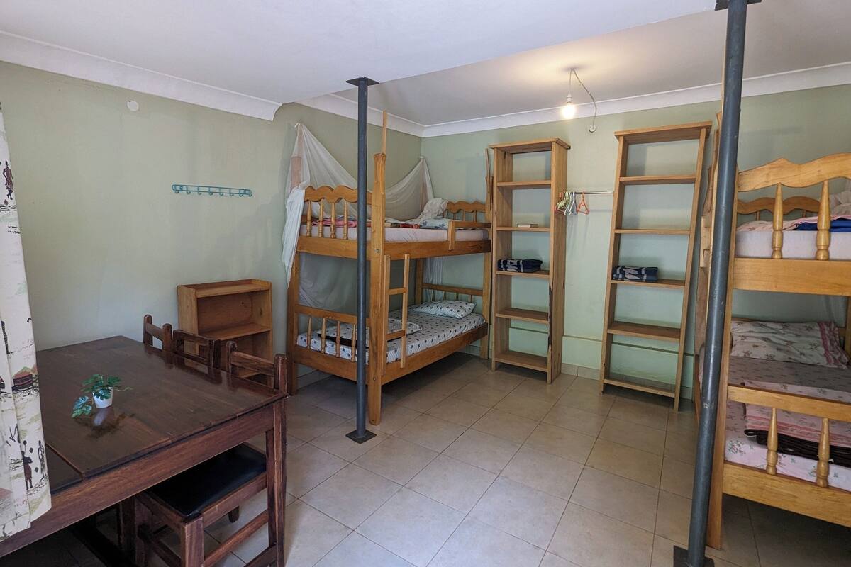 Un dormitorio con literas, un escritorio de madera y una silla.