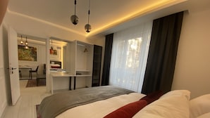 Un dormitorio moderno con una cama grande, un escritorio y un vestidor.