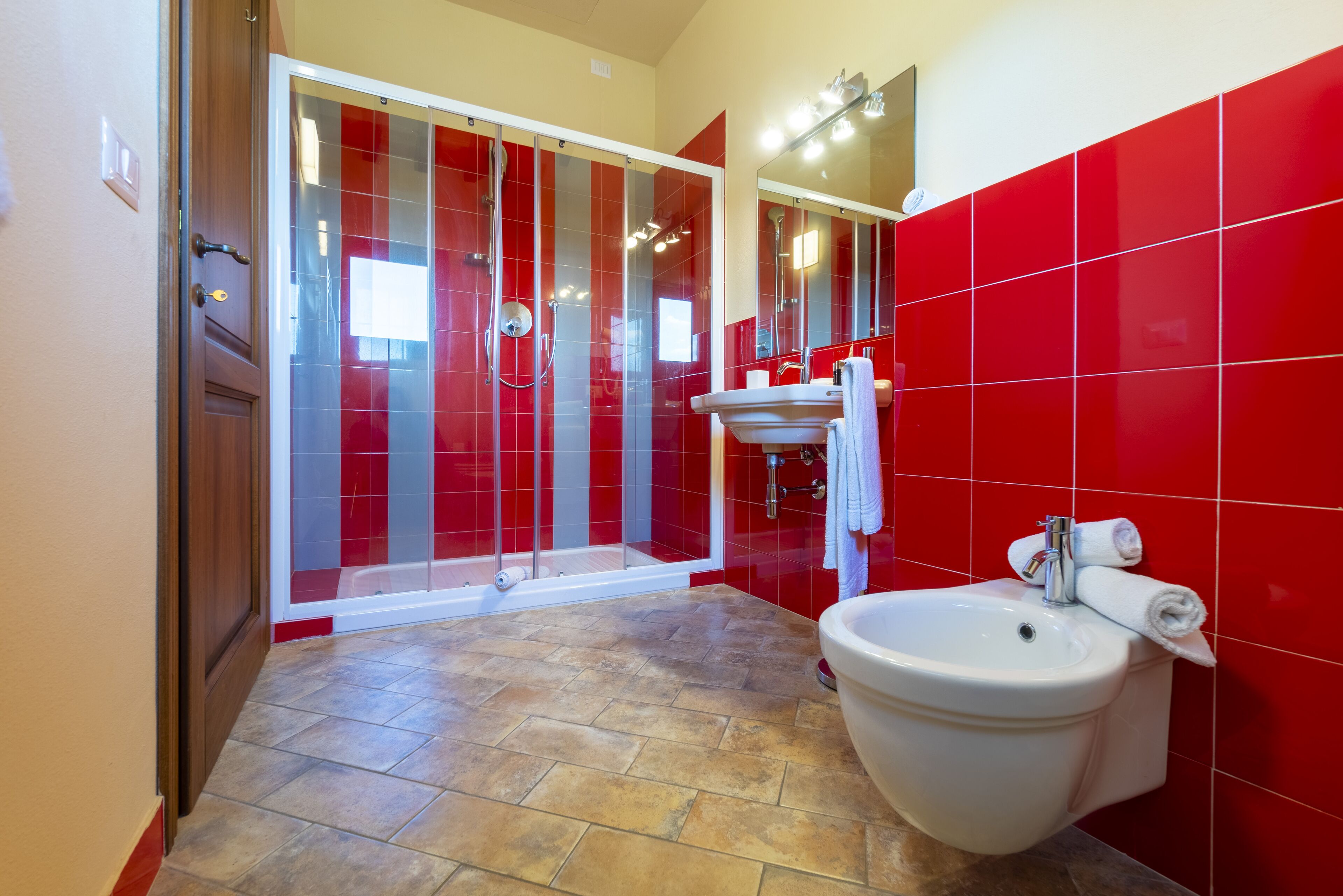 A bathroom with a shower, sink, and toilet.