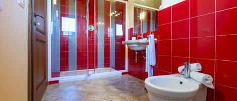 A bathroom with a shower, sink, and toilet.