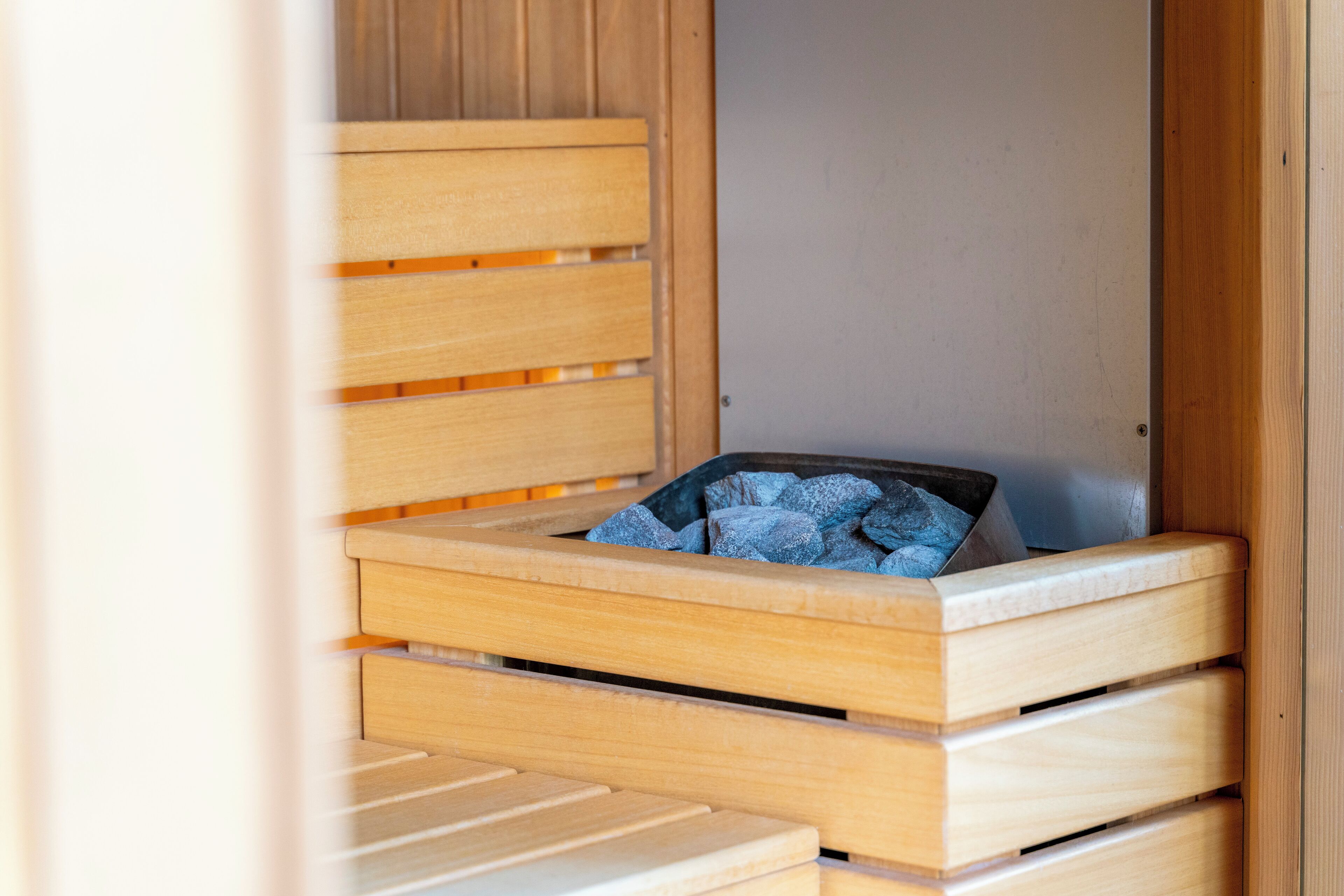 Een houten bed met een matras en een deken.