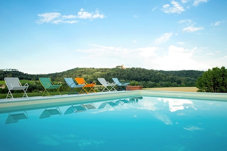 Una piscina al aire libre de temporada, sombrillas