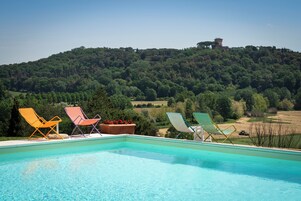 季节性开放的室外游泳池，10:00 至 19:00 开放，池畔遮阳伞，日光浴躺椅