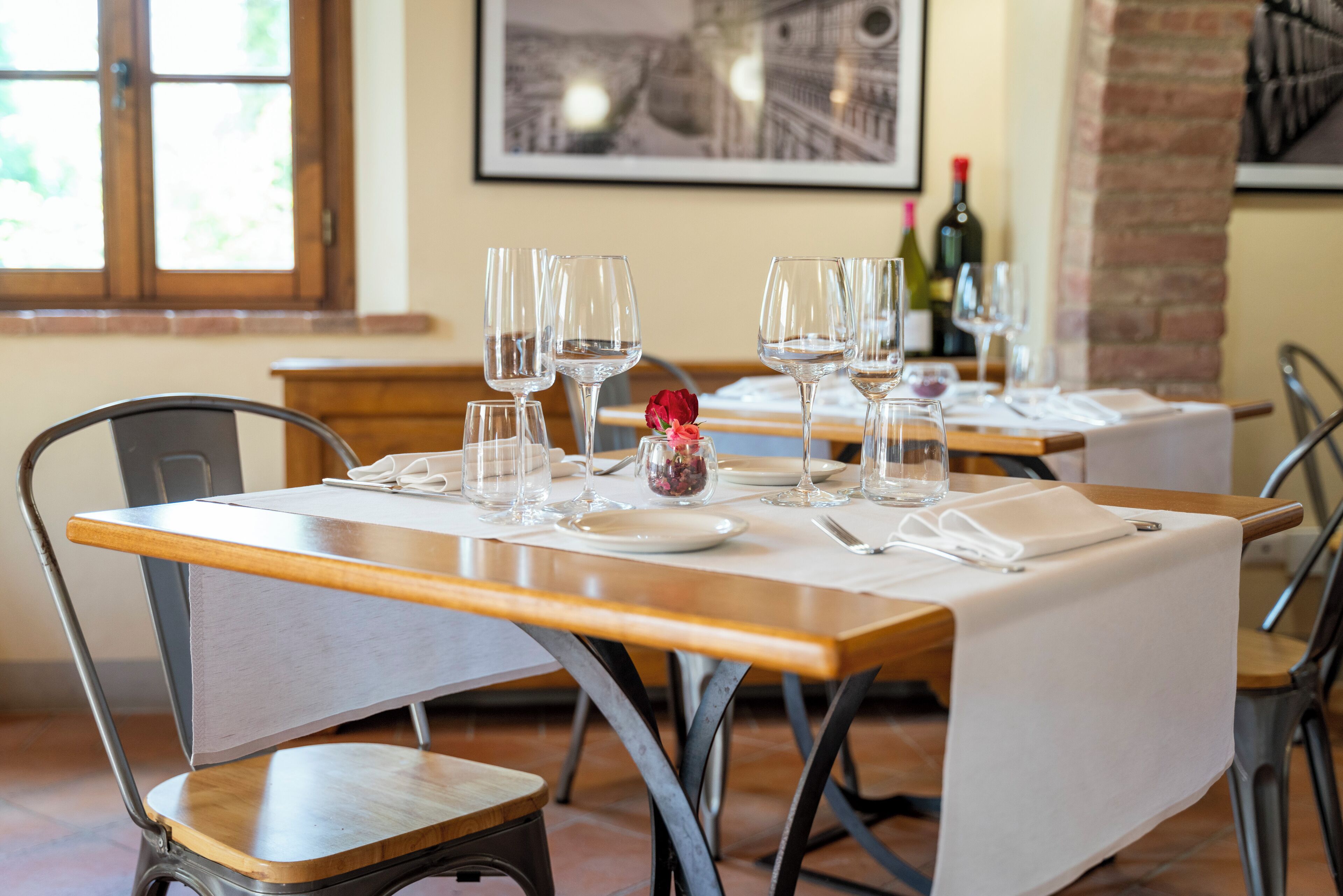 A dining area with a table set for four, including wine glasses, plates, and cutlery.