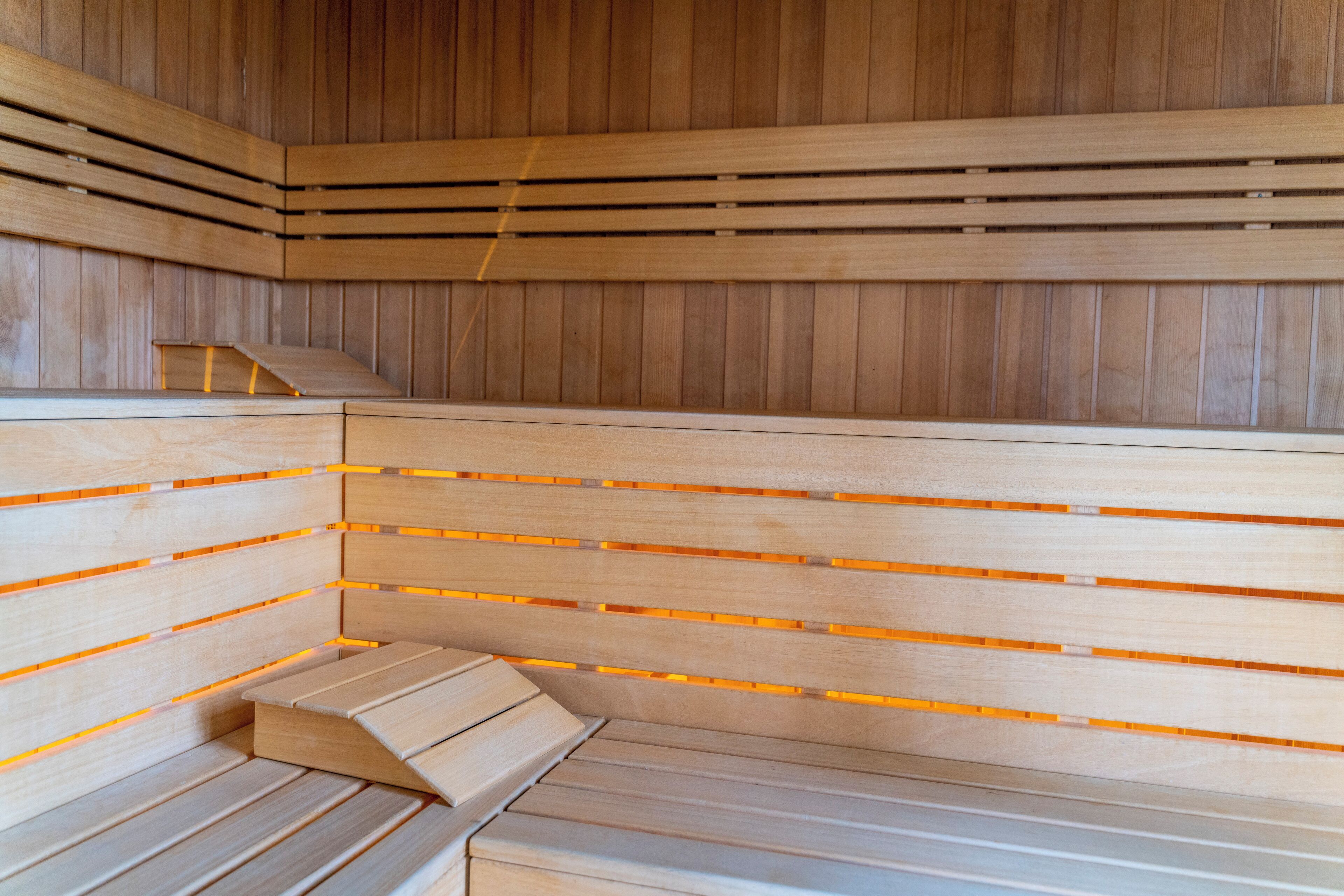 Un sauna avec des bancs en bois et des parois à lattes.