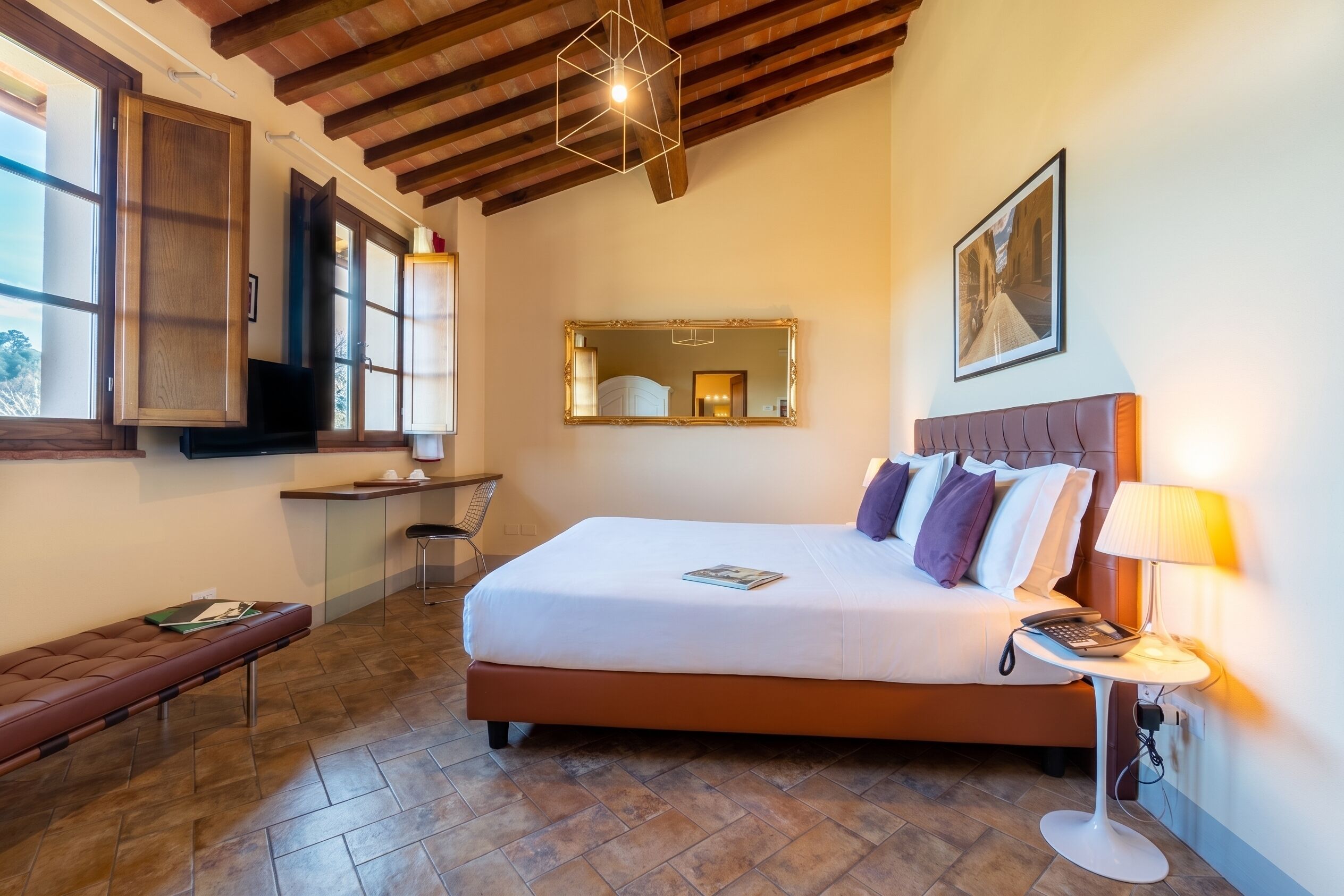 A bedroom with a bed, bedside table, lamp, and a window.