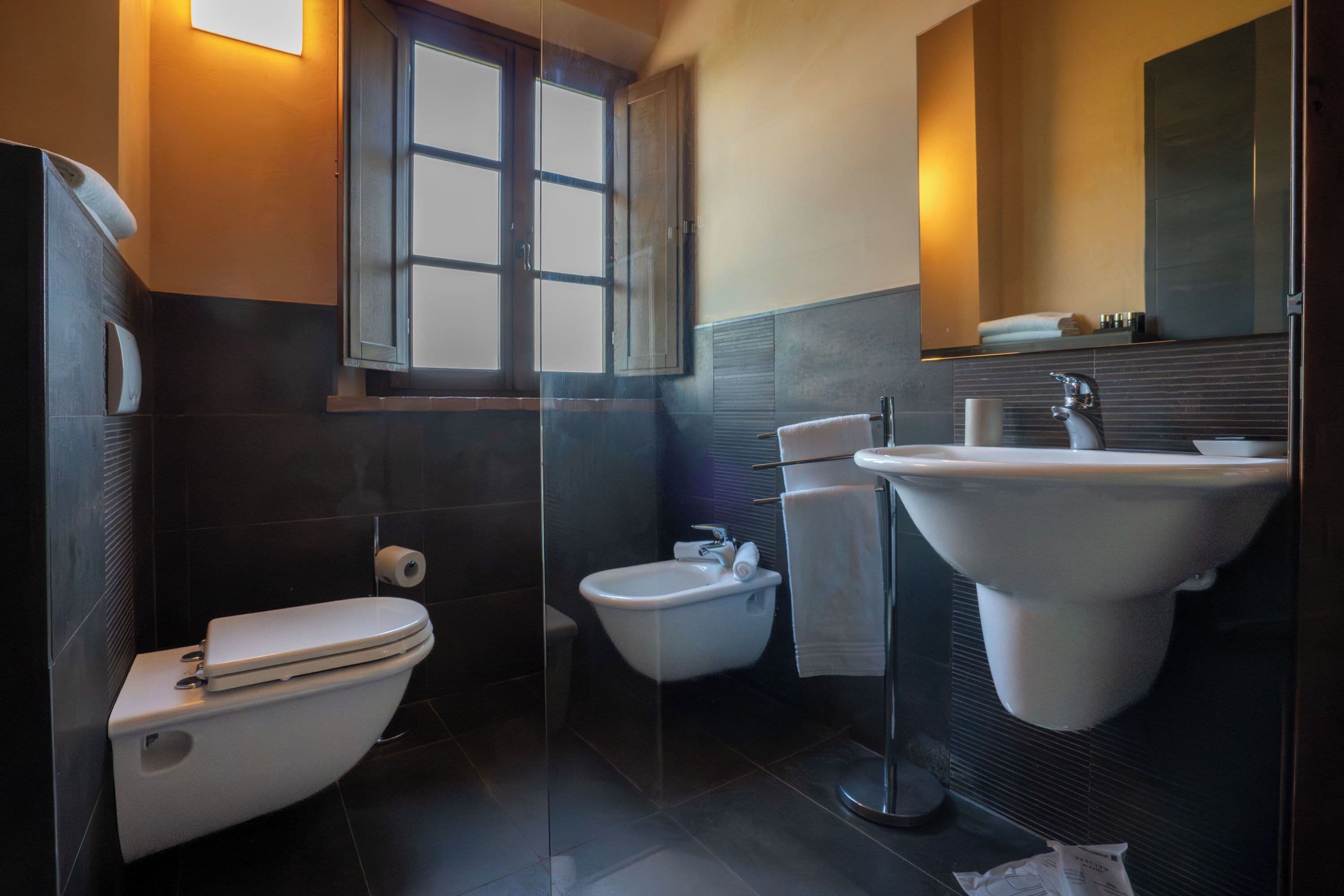 A modern bathroom with a toilet, bidet, and large sink.