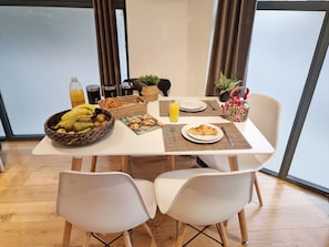 A breakfast table with a fruit bowl, croissant, juice, and a basket of pastries. - Urban Stay Shard View Apartments (London)