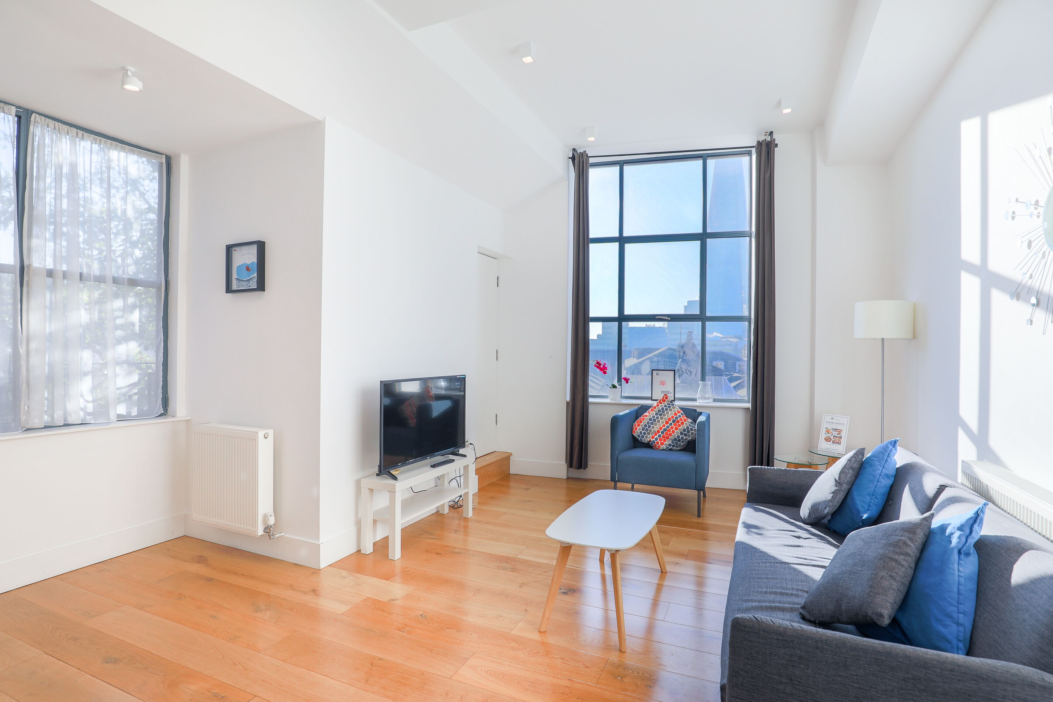 A modern living room with a TV, sofa, and coffee table.