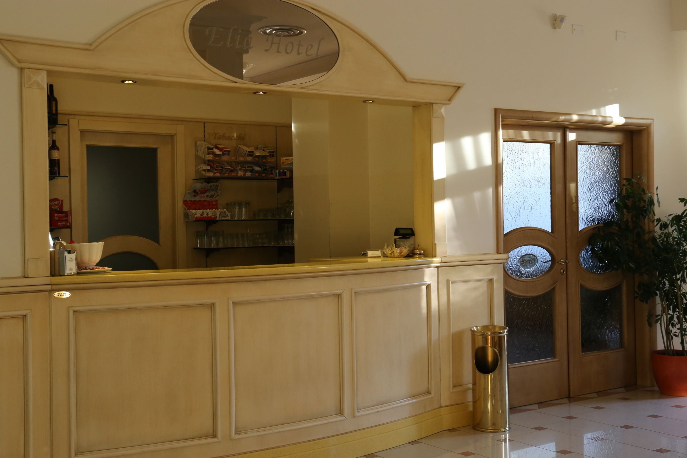 A reception area with a counter, a trash bin, and a door with frosted glass panels.