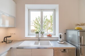 Una cocina moderna con un lavamanos doble, una cafetera y un refrigerador.