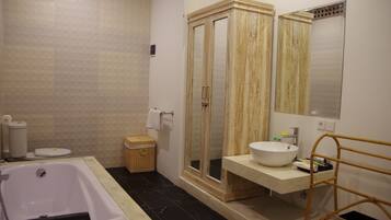 Un baño con bañera, un armario de madera con espejo, un lavabo y una pequeña cesta de mimbre.