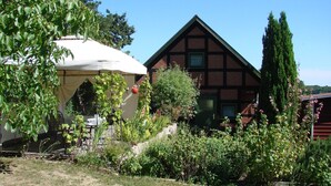 Una casa tradicional con entramado de madera y un jardín delantero.
