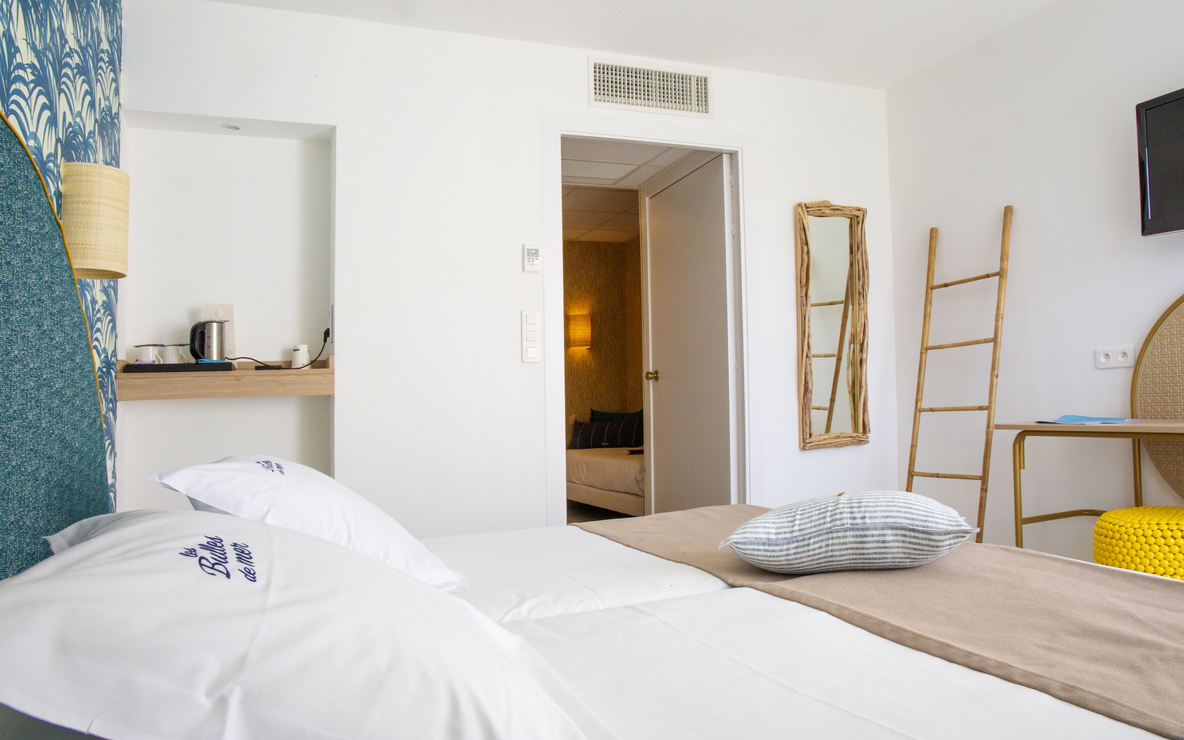 Ein Hotelzimmer mit einem Bett, einem Schreibtisch, einem Stuhl, einem Spiegel und einem Fernseher.