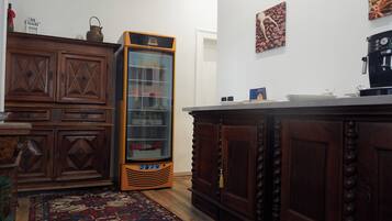 A vintage kitchen with wooden cabinets, a built-in refrigerator, and a patterned rug.