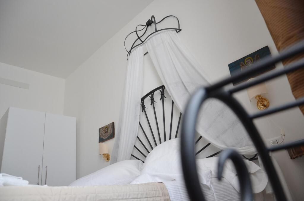 Ein Schlafzimmer mit einem Bett, einem weißen Wandschrank und einem an der Wand hängenden Bild.