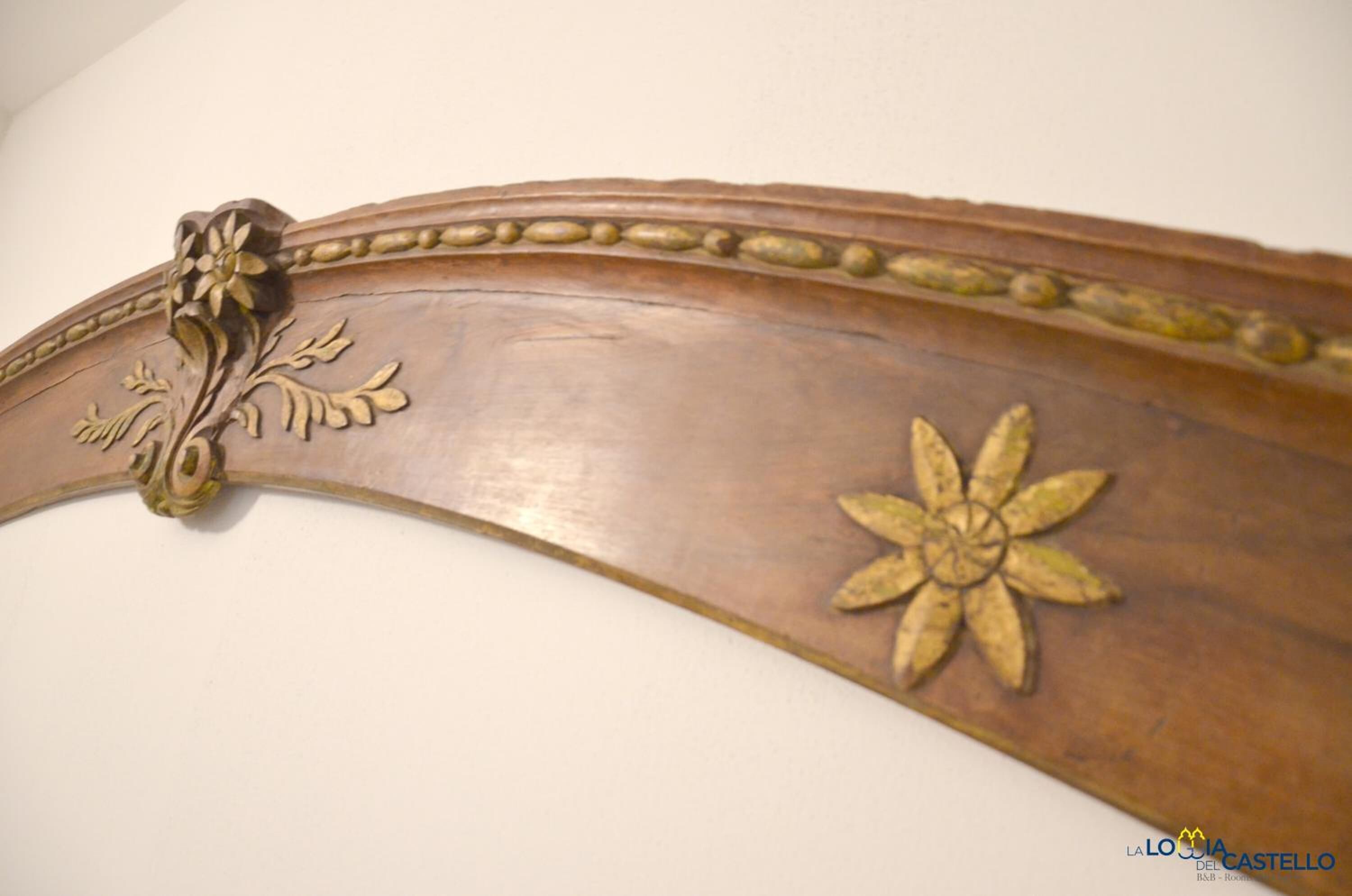 A wooden piece with floral carvings and a curved design.