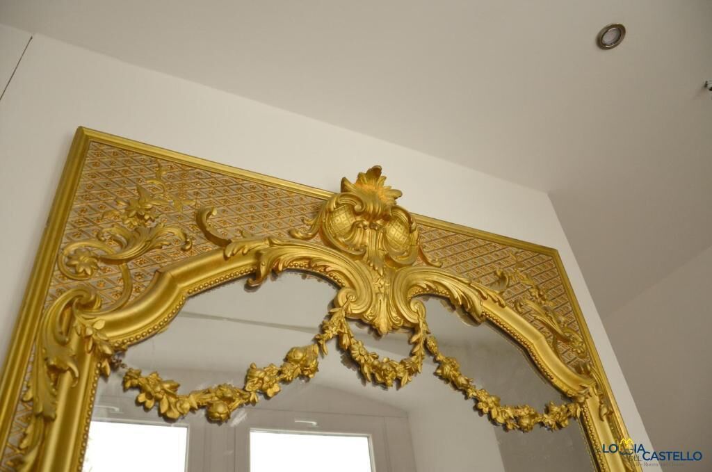 Ein verschnörkelter goldener Rahmen mit aufwendigen Verzierungen, vermutlich Teil einer Raumgestaltung.