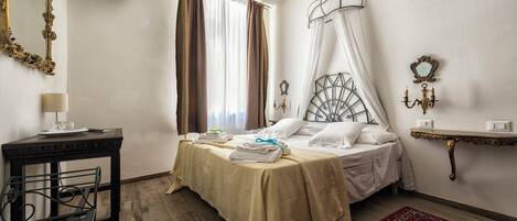 Un dormitorio con cama, mesita de noche, lámpara y una silla.