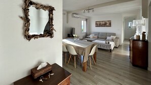 Un espacio habitable amplio con una mesa de comedor, sofá y un espejo en la pared.