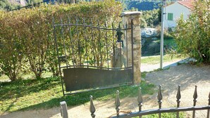A stone gate with a metal fence in a garden setting.