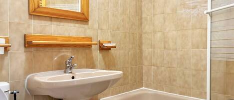 A bathroom with a white sink, a mirror, and a bathtub.