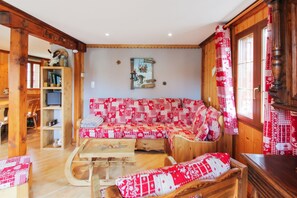 A cozy room with a wooden sofa, a wooden coffee table, and a bench with red and white patterned cushions. - Homerez - Chalet in Stosswihr (Stosswihr)