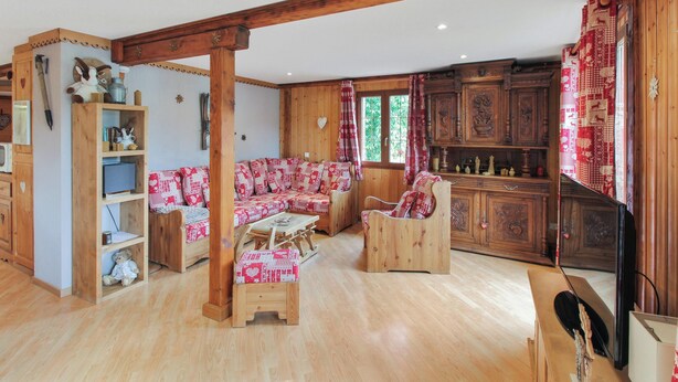 Un salon chaleureux avec des meubles en bois, un ensemble de canapés et un buffet en bois.