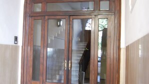 Una puerta doble de madera con paneles de vidrio y un arco semicircular superior.