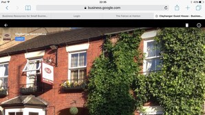 A red brick building with a B&B sign, ivy-covered walls, and a private entrance sign.